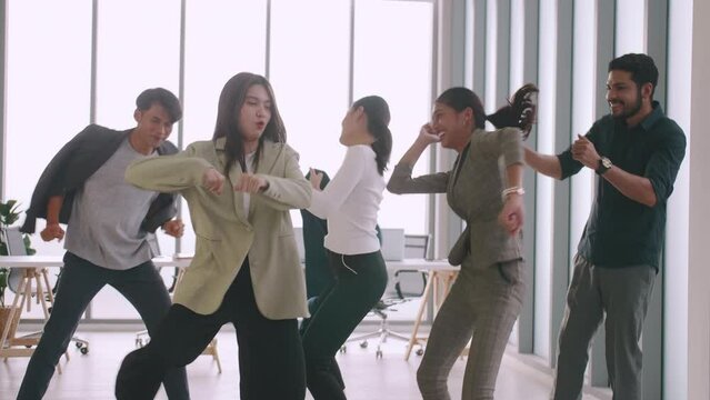 Business people celebrating by dancing at a meeting in office.