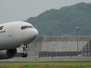 曇り空の下、離陸していく旅客機の機首