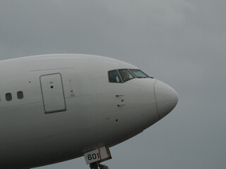 曇り空の下、離陸していく旅客機の機首
