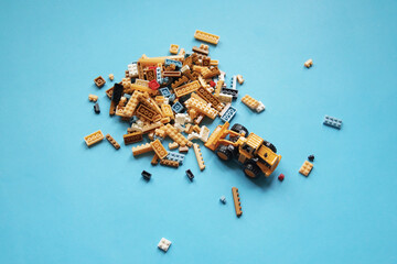 Group of plastic toys and bulldozer on blue background.