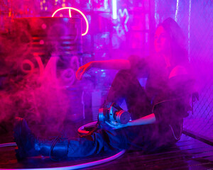 Caucasian woman posing in fog in neon studio.