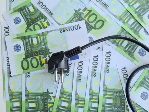 Electrical outlet with euro banknotes closeup. Cost and inflation rise in price of electricity in Europe