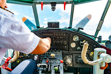 Airplane cockpit. The aircraft instrument panel biplane and the pilot's hand are out of focus.