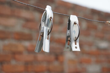 An image of silver steal cloths pins on a clothesline.
