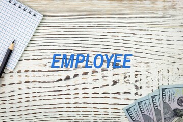 Naklejka premium EMPLOYEE - word (text) and dollars on a white wooden table, notebook, notepad. Business concept: buying, selling, commerce (copy space).