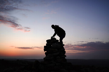 silhouette of a person on the top of raks