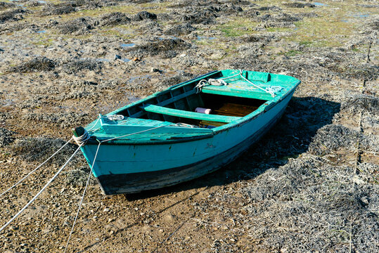 Small boats stranded on the sandy beach at low tide at Brittany, France
