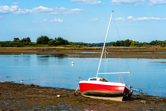 Small boats stranded on the sandy beach at low tide at Brittany, France