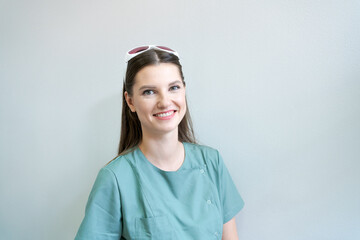 Doctor laser hair removal cosmetics in protective glasses on his head in green coat. Portrait of a beautician in her office in a modern beauty clinic. Preparation for the epilation procedure