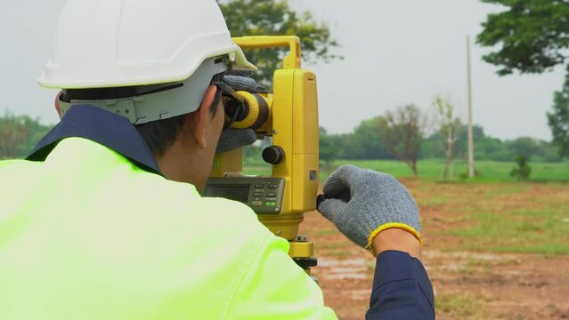 Surveyor engineer with equipment theodolite or total positioning station on the construction site. 
