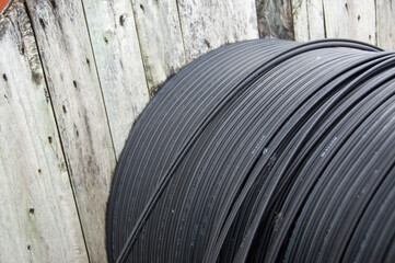 A large coil of black communication cable is outdoors.