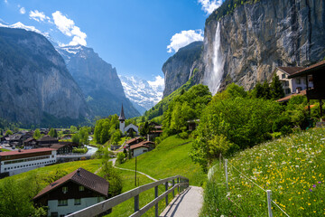amazing alpine landscape in Lauterbrunnen village with church and waterfall in Switzerland - Powered by Adobe