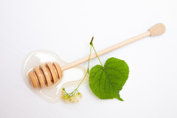 Linden honey and linden flowers on a white background