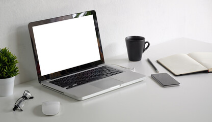 Comfortable workplace with computer laptop, coffee cup, notebook, picture frame and flower pot..