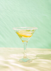 A refreshing summer drink with lemon and ice in a glass under water. Minimal creative concept.