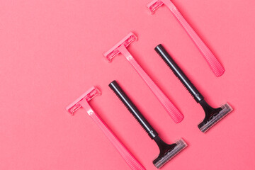 Female Hygiene Concepts. Closeup Image of Five Colorful Pink and Black Disposable Razors Shavers Placed Together Over Trendy Pink Coral Background.