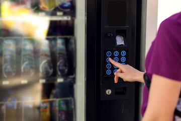 Hand presses button of vending machine. Self-used technology and consumption concept - obrazy, fototapety, plakaty