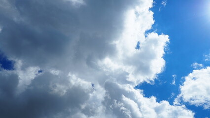 background of white thick cumulus clouds on a blue sky on a sunny bright day