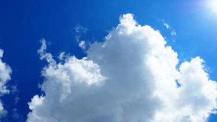 background of white thick cumulus clouds on a blue sky on a sunny bright day