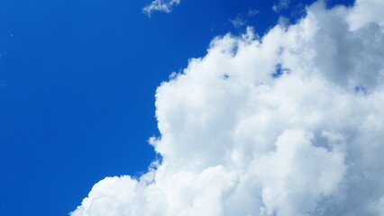 background of white thick cumulus clouds on a blue sky on a sunny bright day