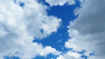 background of white thick cumulus clouds on a blue sky on a sunny bright day