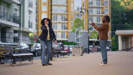 Happy girl recording trendy dancing video for social media account on street.