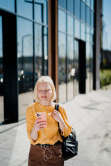 Young happy woman listening music outdoors. Positive blonde girl with headphones enjoying in sunny day.