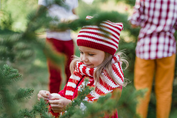 Christmas in july. Child waiting for Christmas in wood in summer. portrait of little girl in red...