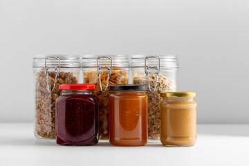 food storage, eating and storage concept - close up of preserves and cereals on table