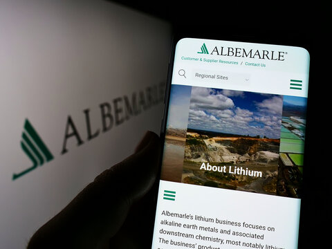 Stuttgart, Germany - 06-12-2022: Person holding cellphone with website of US chemicals company Albemarle Corporation on screen in front of logo. Focus on center of phone display.