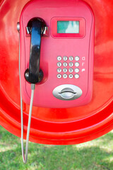 red street phone with black handset on the street