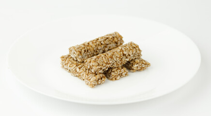 Seed kozinaki with caramel on a white plate.