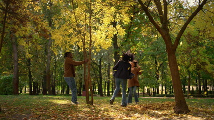 Fototapeta premium Parents daughter rest autumn park enjoying warm sunlight. Happy carefree weekend