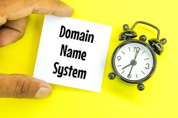 hand holding a white paper with the letters DNS and the word domain name system