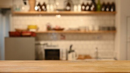 Wooden table and blurred modern kitchen in background. For display or montage your products - obrazy, fototapety, plakaty
