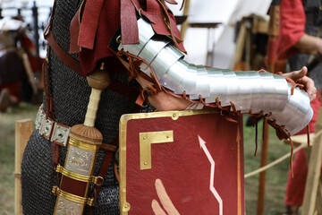 Legionary of Ancient Rome, close up of armor, gladius and scutum of infantry of Roman army on historical reconstruction festival