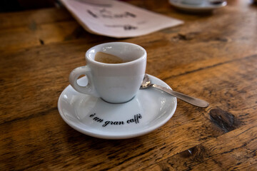 biała filiżankaya spodeczku, w środku aromatyczne espresso