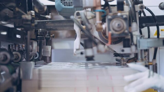 A worker in a printing press prepares printing material.