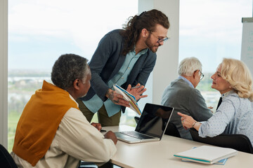 A friendly tutor showing on tablet lesson and explaining use of the social media in modern world.