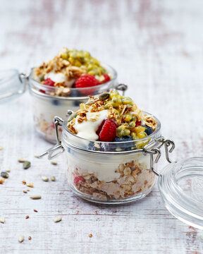 muesli with berries and yogurt on light background