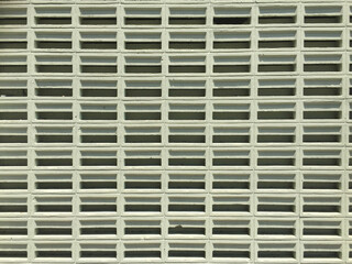 Front view of a series of light green concrete ventilation blocks