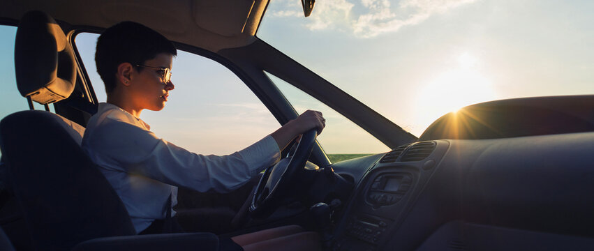 Young Woman Driving Car On A Sunny Summer Day