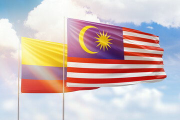 Sunny blue sky and flags of malaysia and colombia