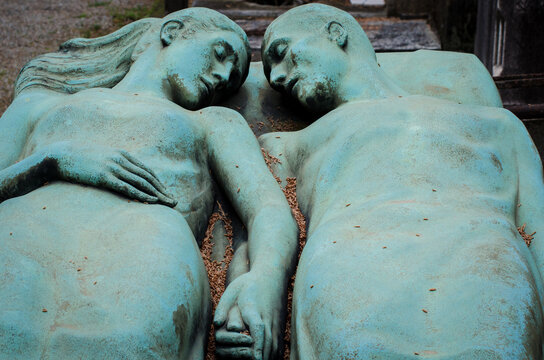 La statua in bronzo di due  amanti che riposano mano nella mano su una tomba del cimitero monumentale di Milano