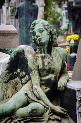 La statua di bronzo ossidato di un angelo sopra una tomba del cimitero monumentale di Milano