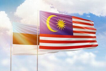 Sunny blue sky and flags of malaysia and estonia