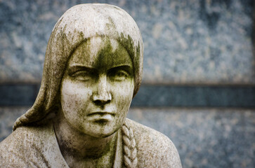 Primo piano del bellissimo volto di una donna scolpita nel marmo e posta su una tomba del cimitero monumentale di Milano