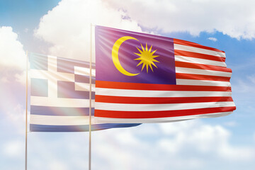 Sunny blue sky and flags of malaysia and greece