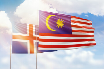 Sunny blue sky and flags of malaysia and iceland