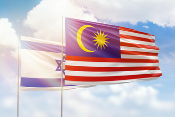 Sunny blue sky and flags of malaysia and israel